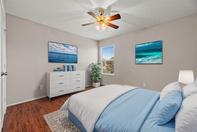 bedroom with ceiling fan, baseboards, and wood finished floors