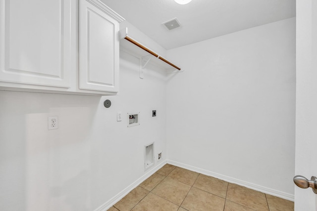 laundry area with gas dryer hookup, cabinets, light tile patterned floors, hookup for a washing machine, and electric dryer hookup