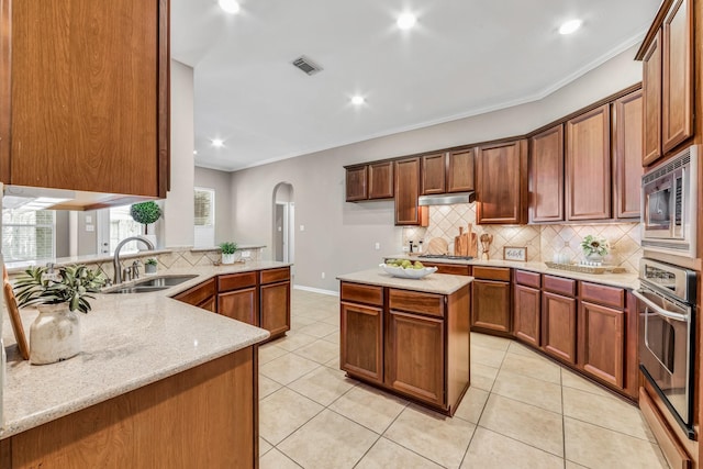 kitchen featuring crown molding, backsplash, stainless steel appliances, light stone counters, and kitchen peninsula