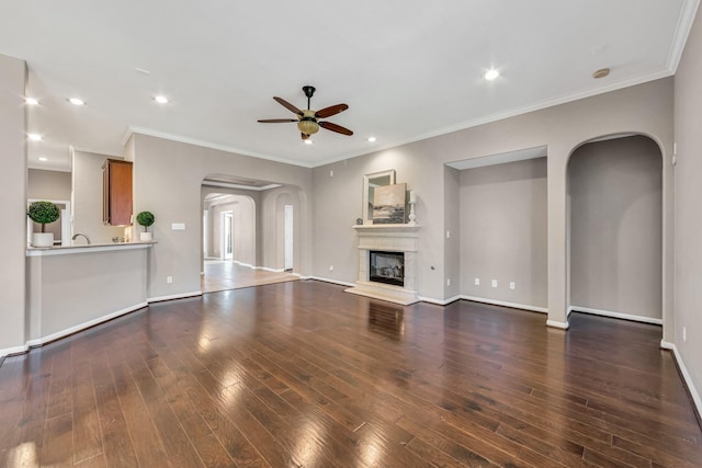 unfurnished living room with crown molding, ceiling fan, and dark hardwood / wood-style floors