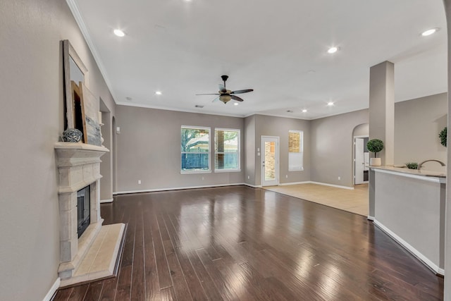 unfurnished living room featuring crown molding, ceiling fan, and wood-type flooring