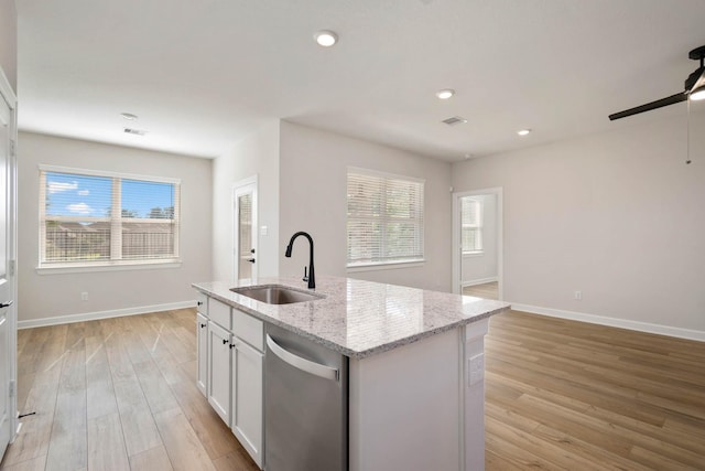 kitchen featuring dishwasher, sink, white cabinets, a kitchen island with sink, and light wood-type flooring