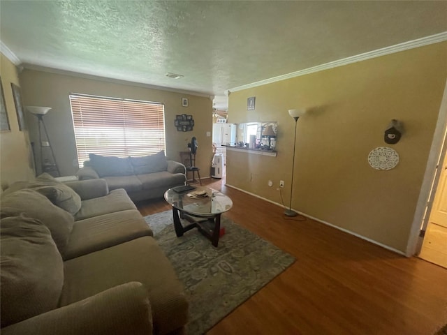 living room with crown molding, wood-type flooring, and a textured ceiling