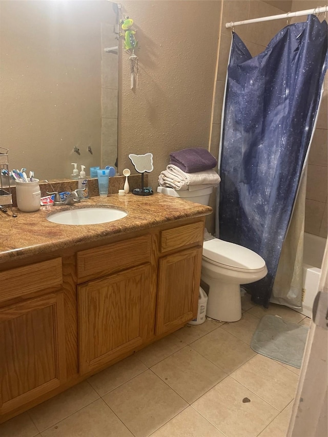 full bathroom with shower / bath combo with shower curtain, tile patterned floors, toilet, and vanity