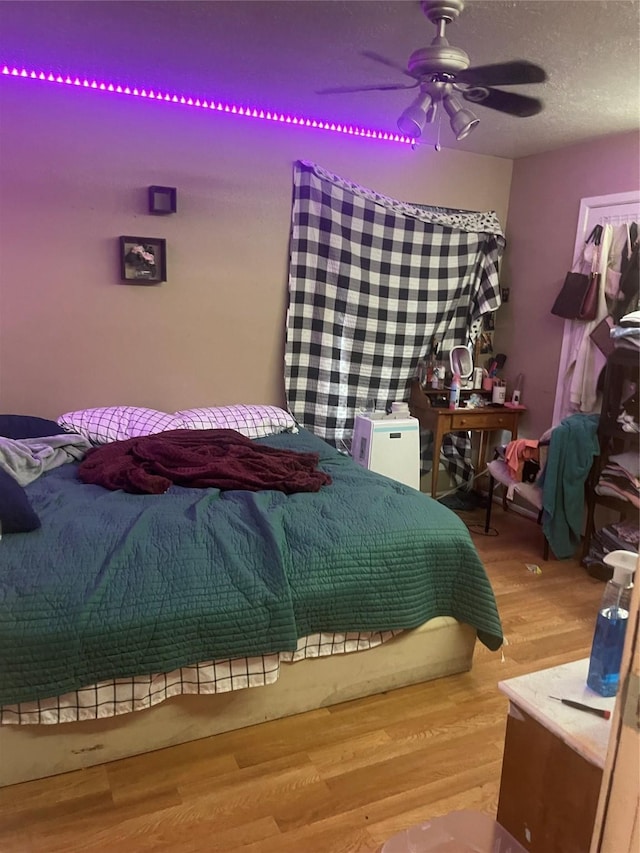 bedroom featuring hardwood / wood-style flooring, ceiling fan, and a textured ceiling