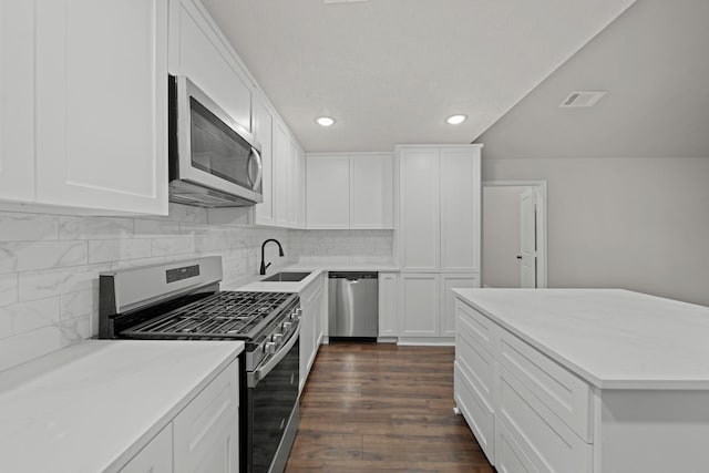 kitchen with stainless steel appliances, sink, white cabinets, and dark hardwood / wood-style floors