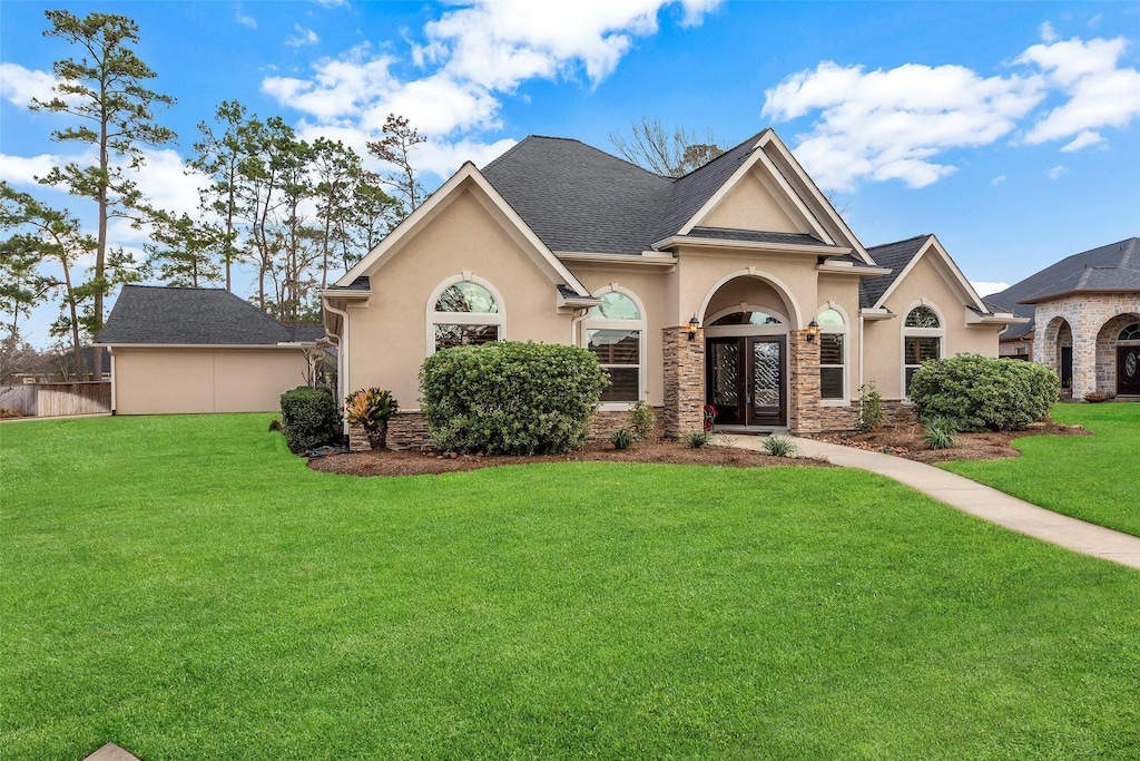 view of front facade featuring french doors and a front lawn