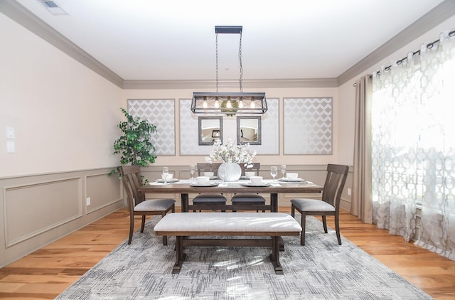 dining area with crown molding and hardwood / wood-style floors