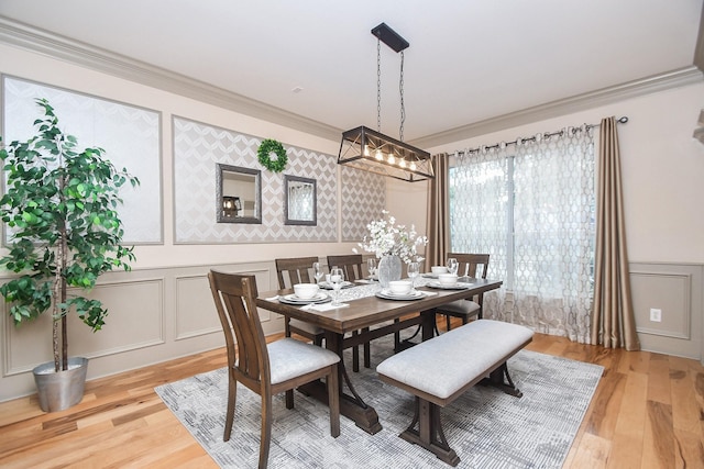 dining area with ornamental molding and light hardwood / wood-style floors