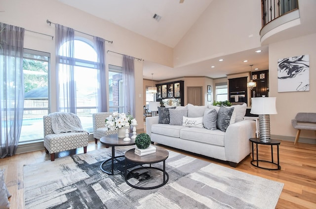 living room with high vaulted ceiling, hardwood / wood-style floors, and a wealth of natural light