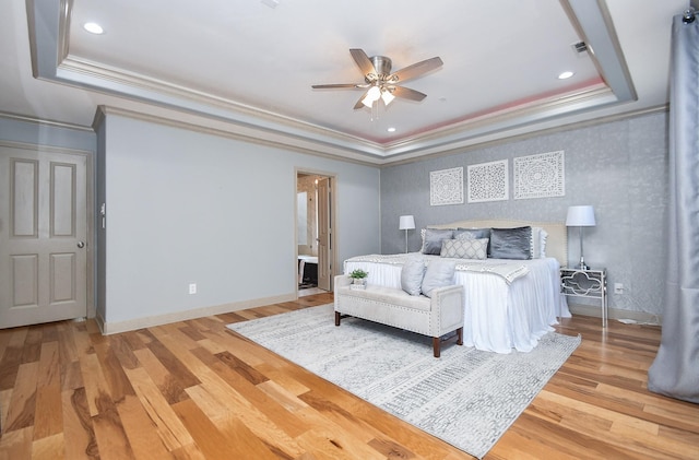 bedroom with crown molding, ceiling fan, a raised ceiling, and light hardwood / wood-style floors