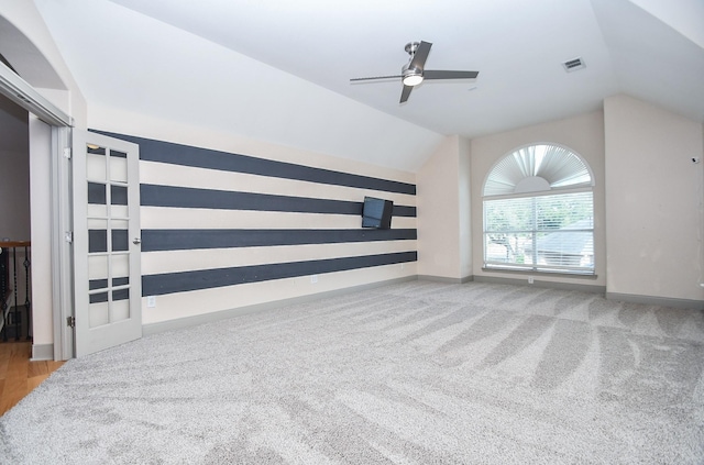 unfurnished living room with ceiling fan, lofted ceiling, and carpet