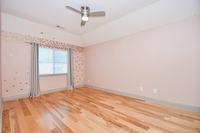 spare room with ceiling fan, wood-type flooring, and vaulted ceiling