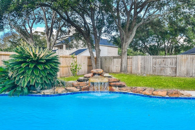 view of swimming pool with pool water feature