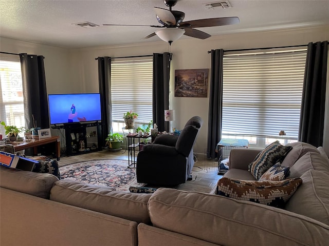 living room with ceiling fan and a textured ceiling