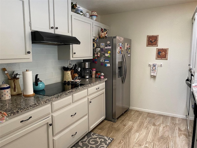 kitchen featuring stainless steel refrigerator with ice dispenser, tasteful backsplash, dark stone countertops, black electric cooktop, and white cabinets