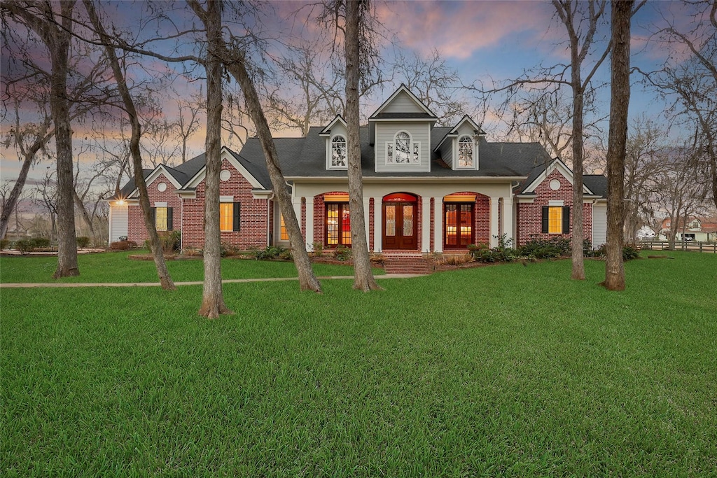 view of front of home with covered porch and a lawn