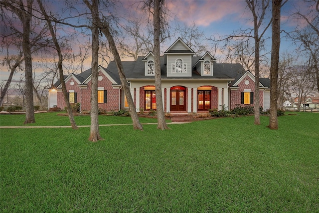 view of front of home with covered porch and a lawn