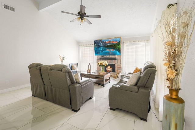 living room featuring ceiling fan, vaulted ceiling with beams, a textured ceiling, and a fireplace