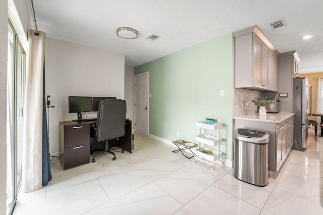 kitchen featuring stainless steel fridge and backsplash