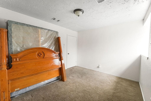 unfurnished bedroom with carpet and a textured ceiling