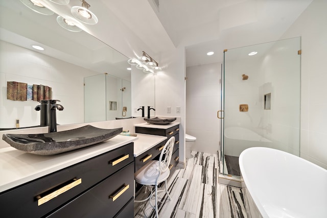 full bathroom featuring independent shower and bath, tile walls, hardwood / wood-style flooring, vanity, and toilet