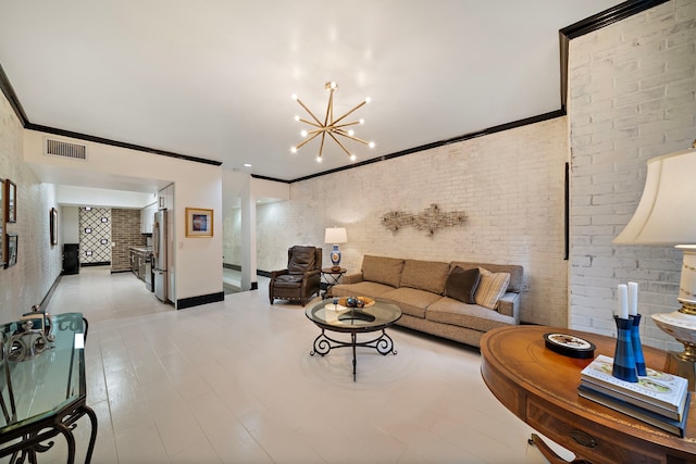 living room featuring crown molding, brick wall, an inviting chandelier, and light hardwood / wood-style floors