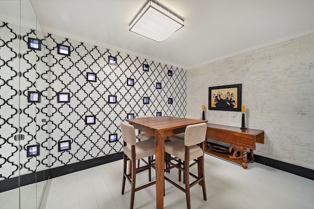 dining space featuring crown molding, brick wall, and light hardwood / wood-style flooring