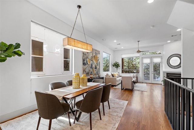 dining room with french doors, a fireplace, recessed lighting, wood finished floors, and baseboards