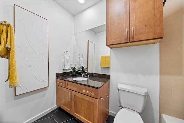 bathroom with baseboards, vanity, toilet, and tile patterned floors