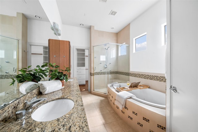 bathroom featuring a walk in closet, visible vents, a stall shower, a bath, and tile patterned floors