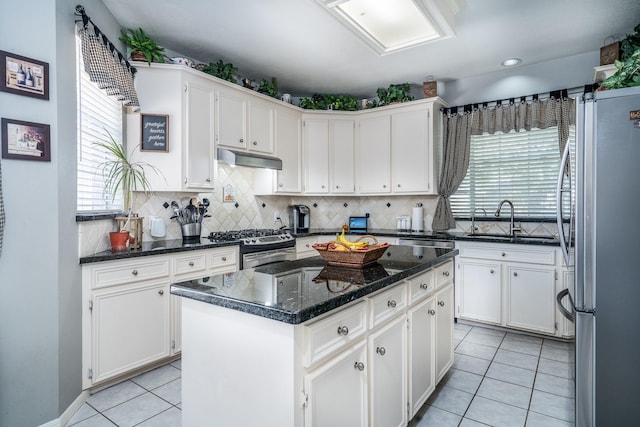 kitchen with a kitchen island, appliances with stainless steel finishes, sink, and white cabinets