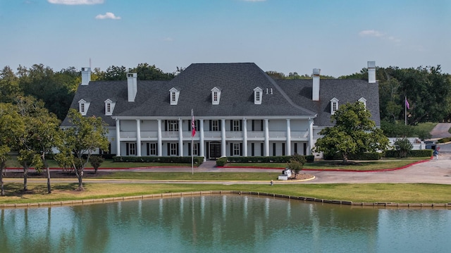 back of property featuring a water view and a yard