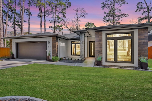 view of front of house with a garage and a yard