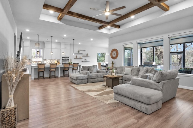 living room with ceiling fan, coffered ceiling, light hardwood / wood-style floors, and beam ceiling