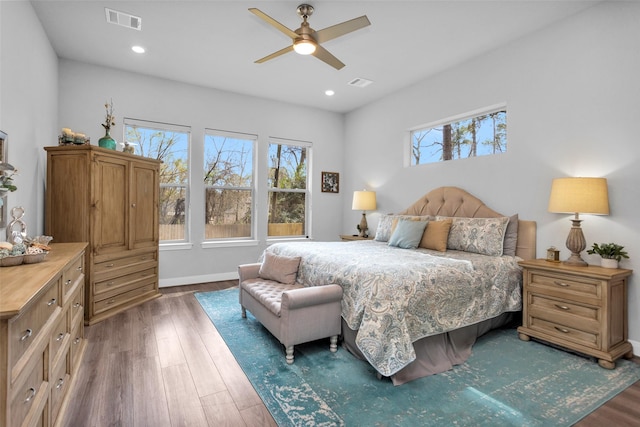 bedroom with ceiling fan, dark hardwood / wood-style floors, and multiple windows