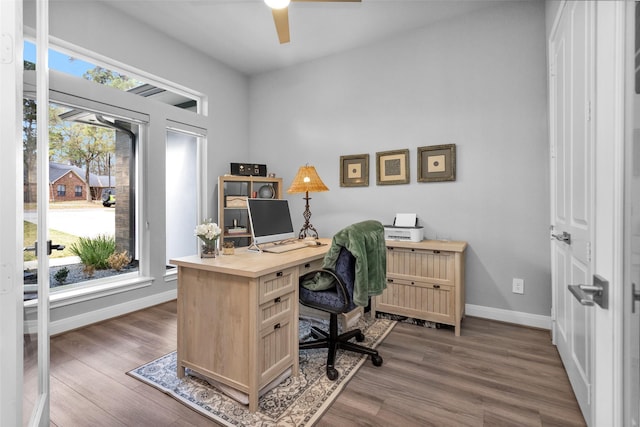 home office with dark hardwood / wood-style flooring and ceiling fan