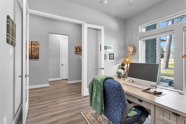 home office with light hardwood / wood-style floors