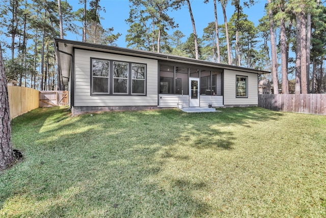 back of house featuring a yard and a sunroom