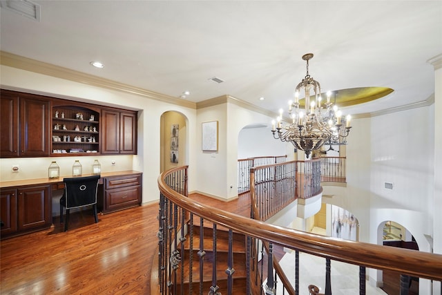 interior space featuring light wood-style floors, visible vents, crown molding, and an upstairs landing