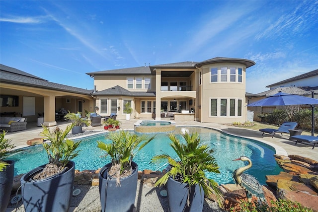 rear view of property with a patio area, stucco siding, a fenced in pool, and an in ground hot tub