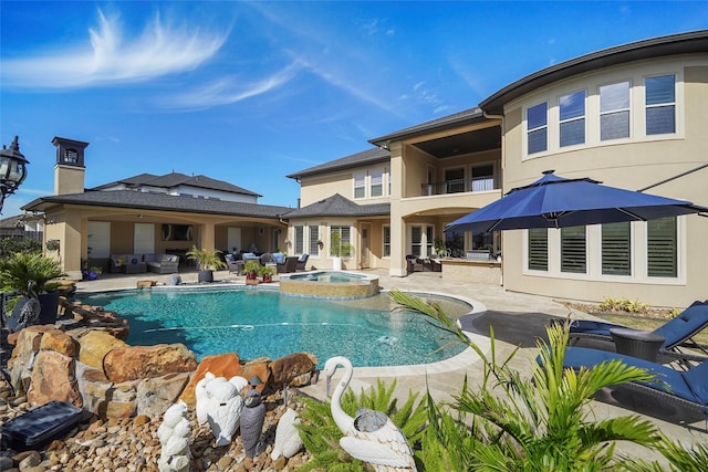 view of swimming pool with a pool with connected hot tub, a grill, and a patio