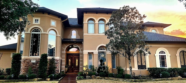 view of front of house featuring a shingled roof and stucco siding