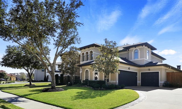 view of front of house featuring a garage, stucco siding, concrete driveway, and a front yard