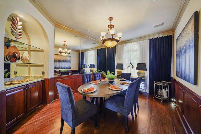 dining room featuring a chandelier, visible vents, ornamental molding, and wood finished floors