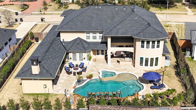 back of property with stucco siding, a fenced backyard, a shingled roof, and a patio