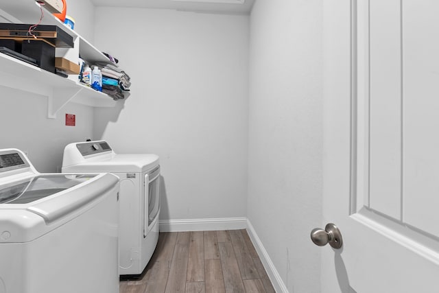 laundry area with washer and clothes dryer and hardwood / wood-style floors