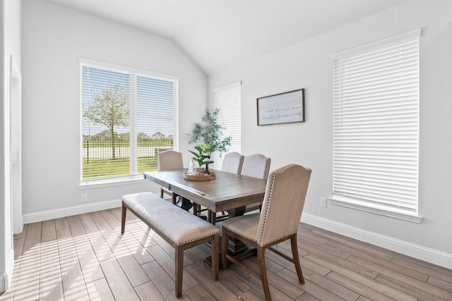 dining room featuring vaulted ceiling and light wood-type flooring