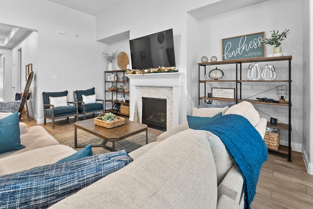 living room featuring a stone fireplace and light hardwood / wood-style floors