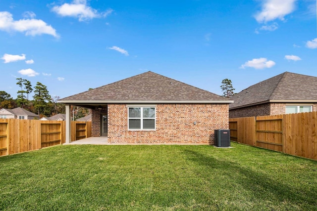 back of house with central AC, a patio, and a lawn